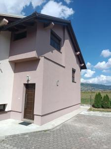 a pink building with a door on the side of it at Apartman Zdenka 2 in Livno