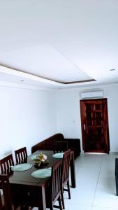 a dining room with a table and chairs and a door at Jp Appartement in Lomé