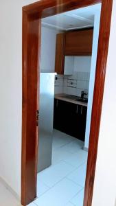 a kitchen with a white refrigerator in a room at Jp Appartement in Lomé