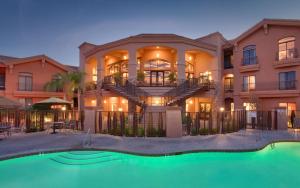 um grande edifício com uma piscina em frente em Embassy Suites Tucson - Paloma Village em Tucson