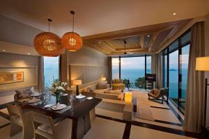 un salon avec une table à manger et un salon dans l'établissement Conrad Koh Samui Residences, à Taling Ngam Beach
