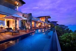 une villa avec une piscine la nuit dans l'établissement Conrad Koh Samui Residences, à Taling Ngam Beach