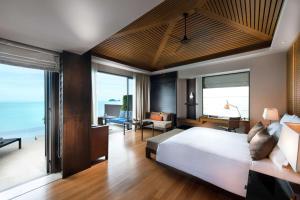 - une chambre avec un grand lit et un salon dans l'établissement Conrad Koh Samui, à Taling Ngam Beach
