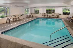 une grande piscine avec des chaises et des tables dans l'établissement Homewood Suites by Hilton Wallingford-Meriden, à Wallingford