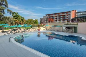 a pool at a hotel with chairs and umbrellas at Hilton Evian Les Bains in &Eacute;vian-les-Bains