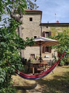 a hammock with a table and an umbrella in a yard at Porcaticcio in Casola Valsenio