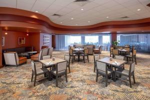 a restaurant with tables and chairs in a room at Embassy Suites Northwest Arkansas - Hotel, Spa & Convention Center in Rogers