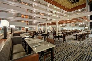 a restaurant with tables and chairs in a room at Embassy Suites by Hilton Omaha Downtown Old Market in Omaha