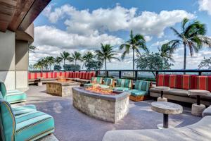 un patio con sillas y mesas y vistas al océano en Hilton Fort Lauderdale Beach Resort, en Fort Lauderdale