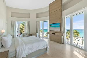 een slaapkamer met een bed en een televisie en de oceaan bij Hilton Fort Lauderdale Beach Resort in Fort Lauderdale