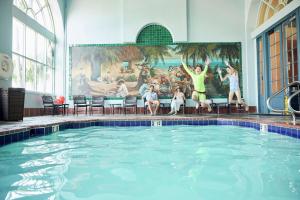 a swimming pool with people jumping in the water at Embassy Suites by Hilton Los Angeles International Airport South in El Segundo
