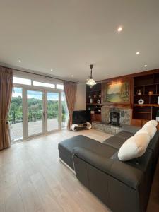 een woonkamer met een bank en een open haard bij Quiet self-catering holiday home with surrounding lakes in Bailieborough