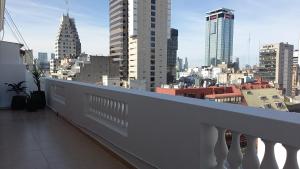 a white balcony with a view of a city at King's Hotel in Buenos Aires