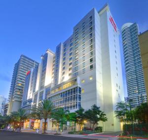 un grand bâtiment blanc avec des palmiers devant lui dans l'établissement Hampton Inn & Suites by Hilton Miami Downtown/Brickell, à Miami