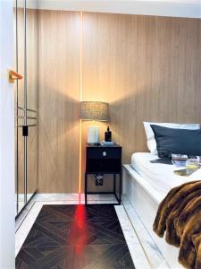 ein Schlafzimmer mit einem Bett mit einem Nachttisch und einer Lampe in der Unterkunft LUXURY Apartment at City CENTER at Palace +Netflix! in Warschau