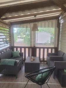 a screened in porch with couches and a table at Mobilhome a Gastes in Gastes
