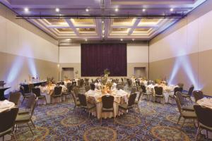a banquet hall with tables and chairs and a screen at Hilton Ponce Golf & Casino Resort in Ponce