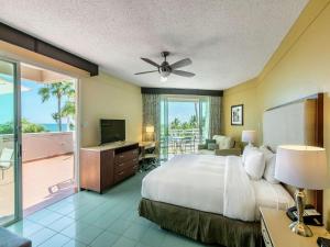 Schlafzimmer mit einem Bett, einem TV und einem Balkon in der Unterkunft Hilton Ponce Golf & Casino Resort in Ponce
