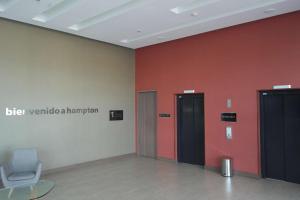 two elevators in a room with red walls and a chair at Hampton By Hilton Valledupar in Valledupar +62 photos
