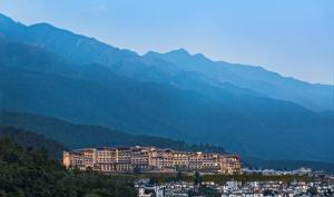 大理的住宿－大理實力希爾頓酒店，一座大建筑,位于山丘上,背景是群山