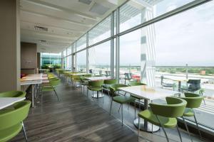 a cafeteria with tables and chairs and windows at Hampton By Hilton Valledupar in Valledupar