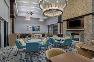 a restaurant with tables and chairs and a fireplace at Homewood Suites by Hilton Atlanta Perimeter Center in Atlanta