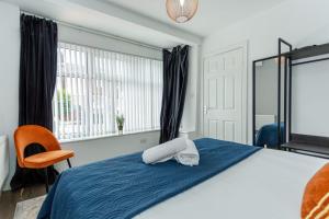 a bedroom with a bed and a chair and a window at Free Parking 5 Minutes from City Centre in Manchester
