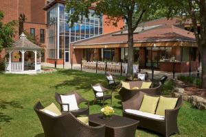 une cour avec des chaises et des tables ainsi qu'un bâtiment dans l'établissement Hilton Mississauga/Meadowvale, à Mississauga