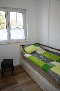 a bed in a bedroom with a window and a chair at Ferienwohnung Melrose - Design & Glasfaser am Silbersee in Lehmbraken