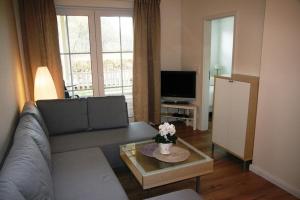 a living room with a couch and a table and a tv at Ferienwohnung Melrose - Design & Glasfaser am Silbersee in Lehmbraken