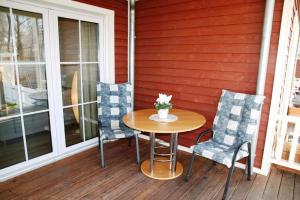 a table and chairs on the porch of a house at Ferienwohnung Melrose - Design & Glasfaser am Silbersee in Lehmbraken