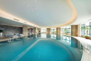 a pool in a hotel lobby with a swimming pool at Hilton Zhoushan in Zhoushan