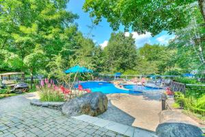 a large swimming pool in a park with trees at Sweet Getaway in Mont-Tremblant