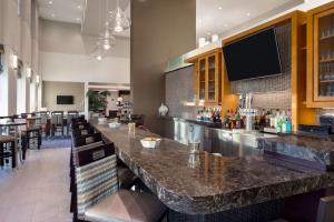 un bar dans un restaurant avec un long comptoir dans l'établissement Hampton Inn & Suites Rosemont Chicago O'Hare, à Rosemont