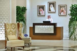 Conrad Makkah في مكة المكرمة: لوبي فندق فيه رجل واقف خلف مكتب
