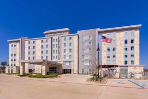 een hotel met een Amerikaanse vlag ervoor bij Hampton Inn & Suites North Houston Spring in Spring