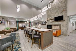 a lobby with a bar with chairs and a fireplace at Hampton Inn & Suites North Houston Spring in Spring