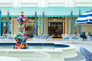 a fountain in the middle of a pool with tables and chairs at Hilton Orlando Buena Vista Palace - Disney Springs Area in Orlando