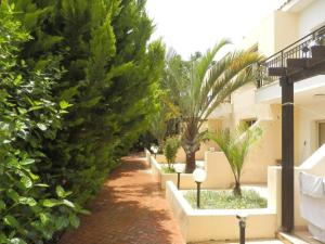 una pasarela con árboles y arbustos junto a un edificio en Byreva Apartments en Pafos