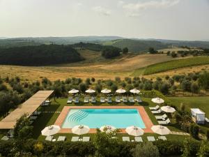 an aerial view of a resort with a pool and umbrellas at Castello Del Nero - Podere San Filippo in Tavarnelle in Val di Pesa