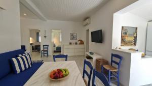 Una sala de estar con una mesa con un bol de fruta encima. en Blue Gem Villa, en Lefkada