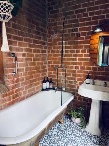 a bathroom with a white bath tub next to a sink at The Shopkeepers Quarters in Tenterfield