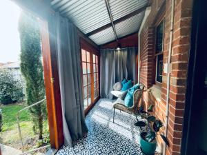 a screened in porch with a couch and a window at The Shopkeepers Quarters in Tenterfield
