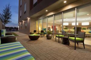 a patio of a building with chairs and tables at Home2 Suites by Hilton Stillwater in Stillwater