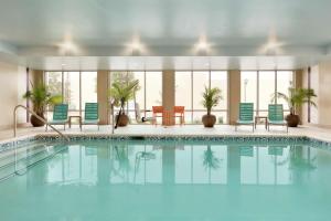 a swimming pool with blue chairs and chairs in a building at Home2 Suites by Hilton Stillwater in Stillwater