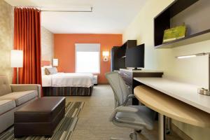 スティルウォーターにあるHome2 Suites by Hilton Stillwaterのベッドとリビングルームが備わるホテルルームです。