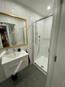 a white bathroom with a sink and a shower at Stylish 1-bed studio in London