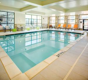 a large swimming pool with blue water in a building at Hilton Garden Inn Dallas/Arlington South in Arlington