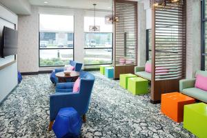 a lobby with chairs and a table and windows at Hilton Garden Inn Dallas/Arlington South in Arlington