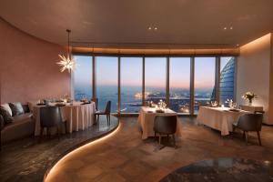 un ristorante con tavoli e sedie e una grande finestra di Conrad Xiamen-Free Mini Bar a Xiamen